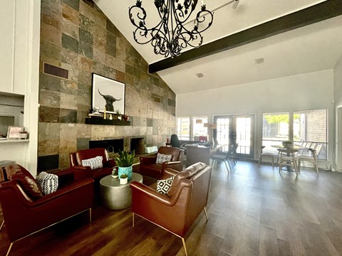 a living room with leather furniture and a stone wall